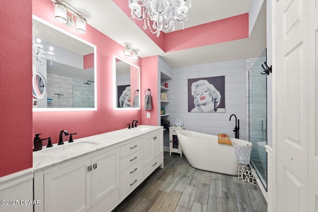 full bathroom featuring wood finished floors, a notable chandelier, and a sink