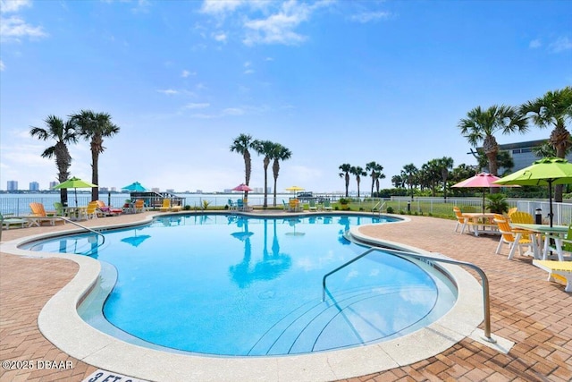 community pool with a patio and fence