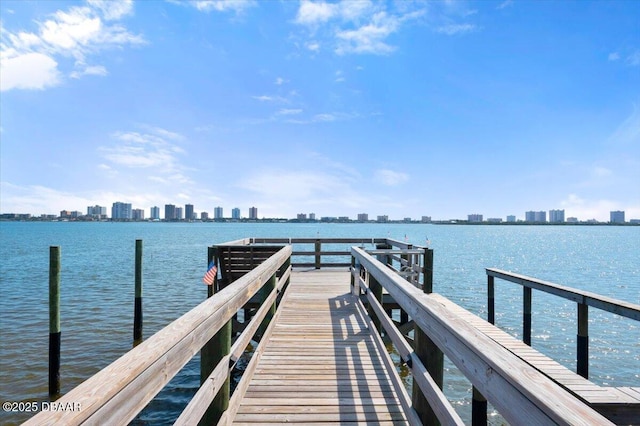 view of dock with a water view and a city view