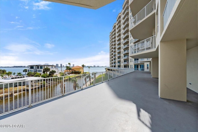 view of patio with a balcony and a water view