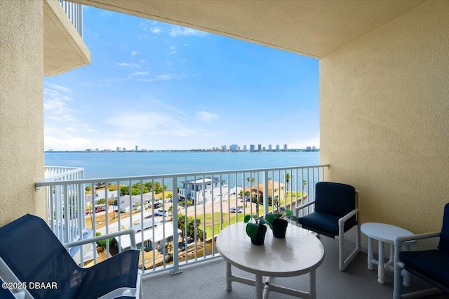balcony featuring a water view and a city view
