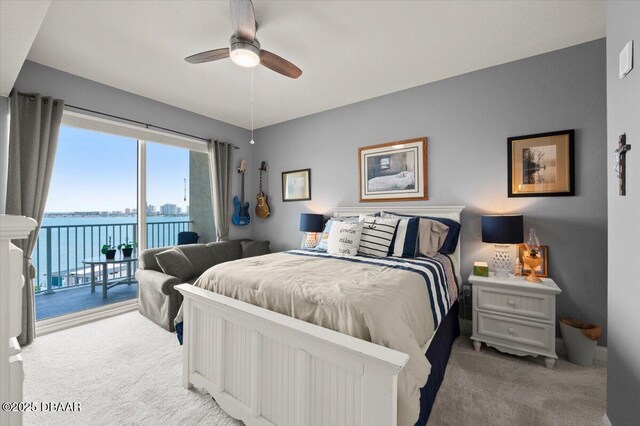 bedroom with ceiling fan, a water view, access to outside, and light carpet