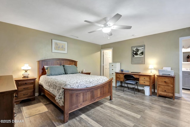 bedroom with ceiling fan, wood-type flooring, and ensuite bath