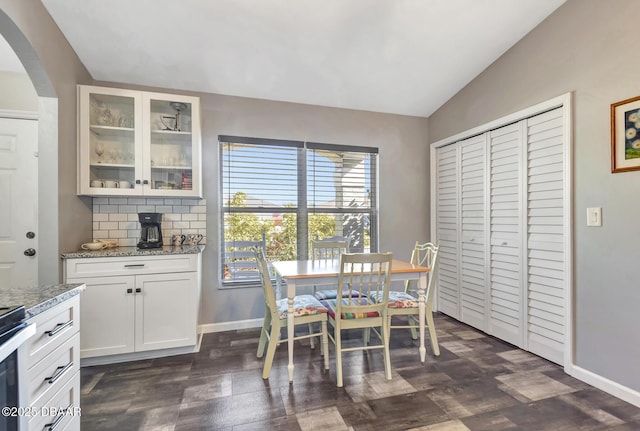 dining space with lofted ceiling and dark wood-type flooring