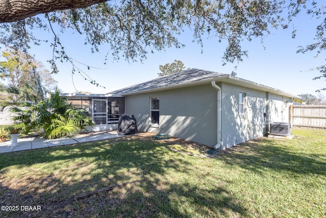 view of home's exterior with a sunroom, a yard, and central air condition unit