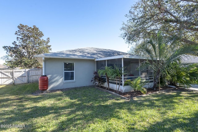 rear view of property featuring a sunroom and a yard