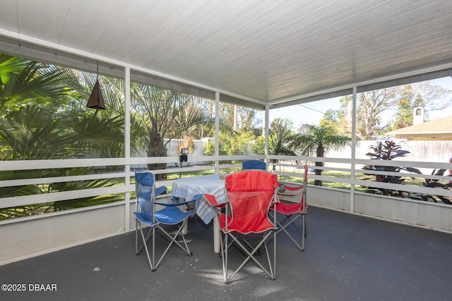 sunroom featuring a water view