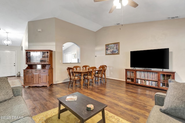 living room with ceiling fan, dark hardwood / wood-style flooring, and vaulted ceiling