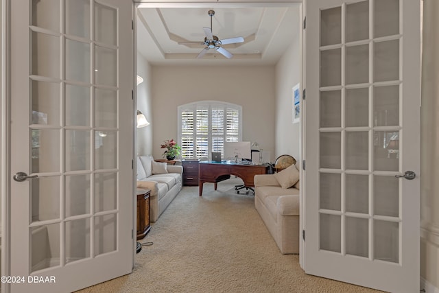 office area with carpet, ceiling fan, and a raised ceiling