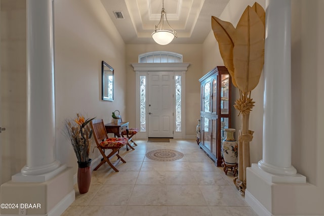 tiled entrance foyer featuring a tray ceiling