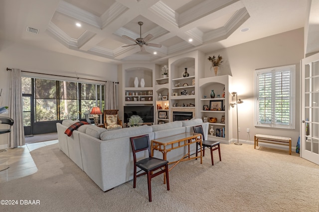 living room with ceiling fan, coffered ceiling, a healthy amount of sunlight, and beamed ceiling