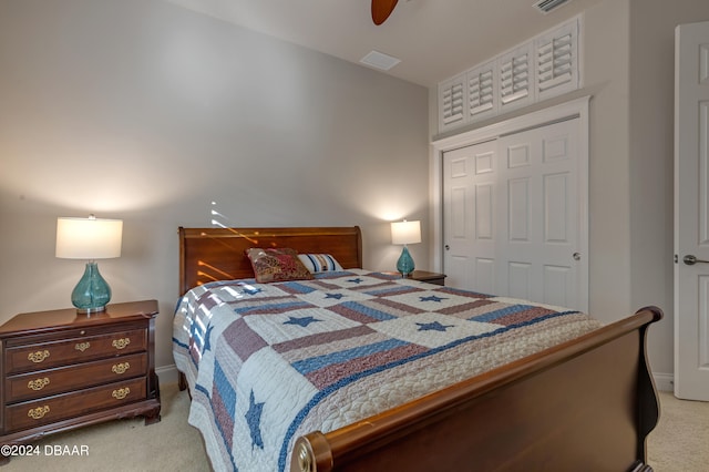 bedroom with ceiling fan, light colored carpet, and a closet