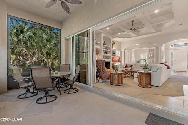 sunroom / solarium featuring ceiling fan, a wealth of natural light, and ornate columns