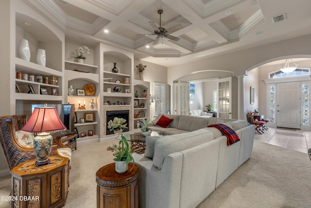 carpeted living room featuring coffered ceiling, ceiling fan, built in shelves, and decorative columns