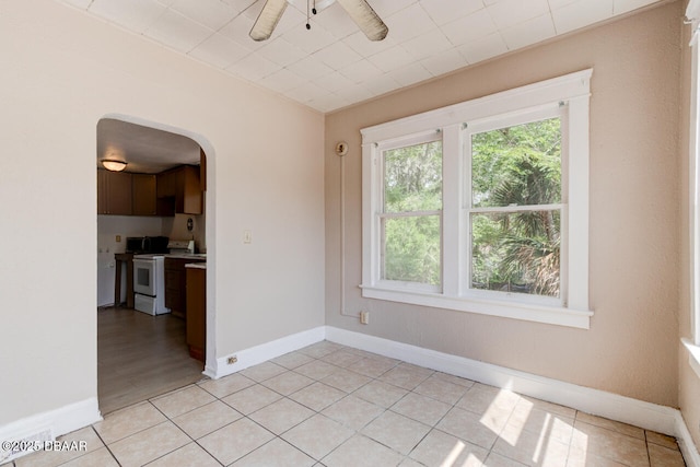 634 Aberdeen St, Daytona Beach, FL 32114 - spare room with arched walkways, ceiling fan, baseboards, and light tile patterned floors