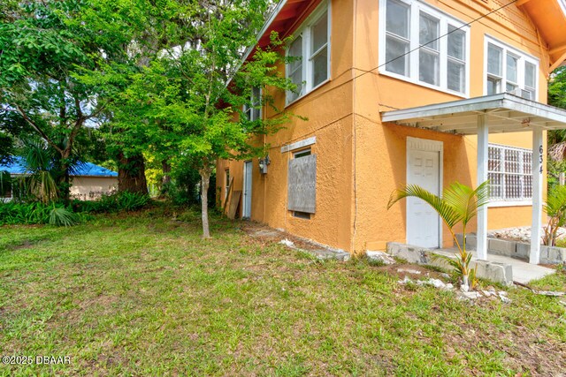 634 Aberdeen St, Daytona Beach, FL 32114 - view of side of property with stucco siding and a yard