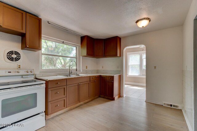 634 Aberdeen St, Daytona Beach, FL 32114 - kitchen featuring electric range, light countertops, a textured ceiling, brown cabinetry, and a sink