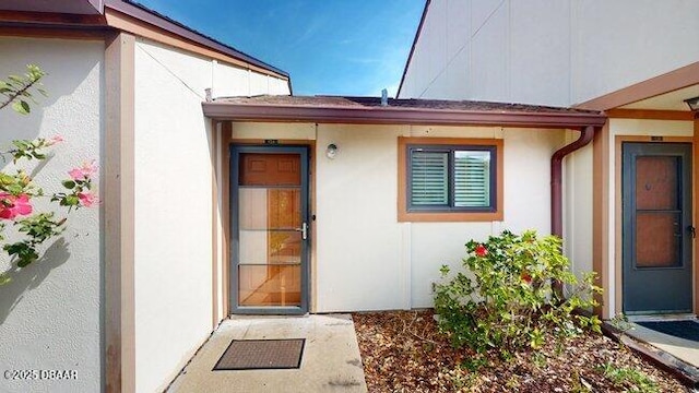 entrance to property featuring stucco siding