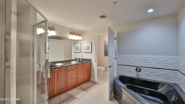 2403 S Atlantic Ave Unit 605, Daytona Beach, FL 32118 - full bath with toilet, double vanity, a tub with jets, tile patterned flooring, and a textured ceiling