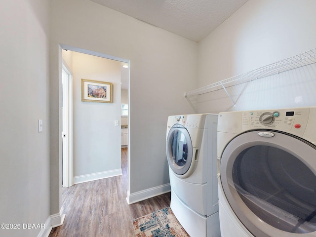 laundry area featuring a textured ceiling, washer and clothes dryer, and hardwood / wood-style floors