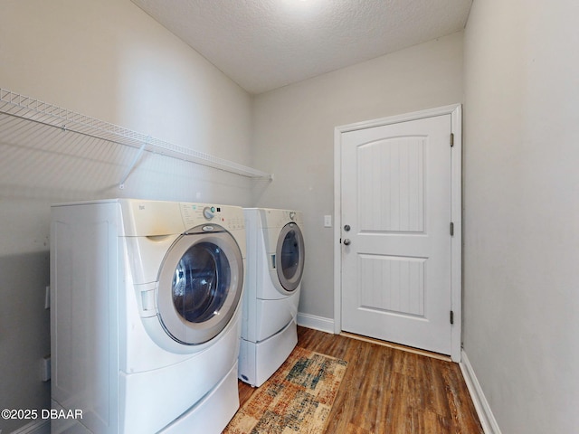 laundry area with a textured ceiling, dark hardwood / wood-style floors, and independent washer and dryer