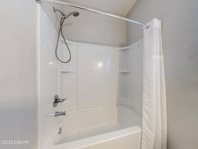 bathroom with a textured ceiling and shower / tub combo