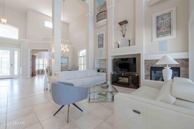 living room featuring a towering ceiling, light tile patterned floors, and a chandelier