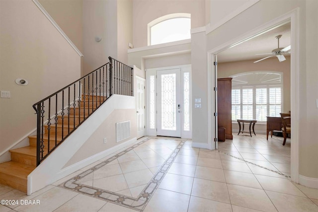 entrance foyer featuring ceiling fan, plenty of natural light, and light tile patterned floors