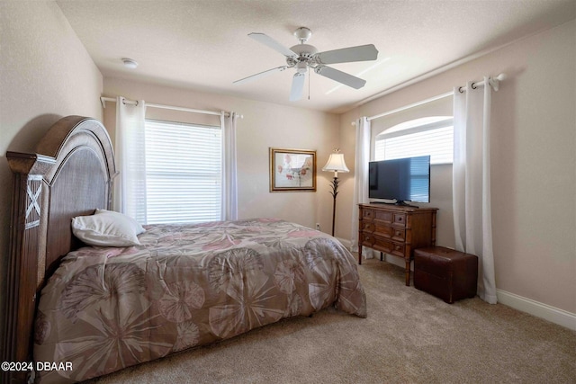 carpeted bedroom featuring ceiling fan and a textured ceiling