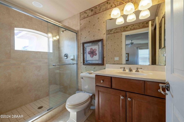 bathroom featuring vanity, ceiling fan, toilet, and a shower with shower door