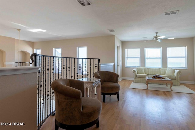 living area with light wood-type flooring and ceiling fan