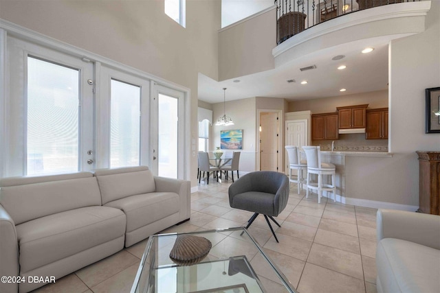 living room with a high ceiling, light tile patterned floors, and french doors