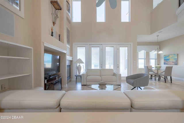 tiled living room featuring french doors and a high ceiling