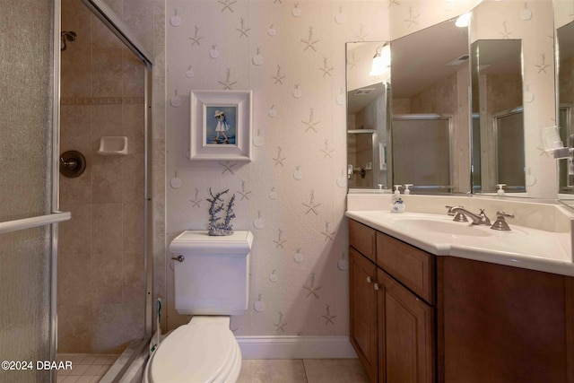 bathroom with toilet, vanity, tile patterned flooring, and walk in shower