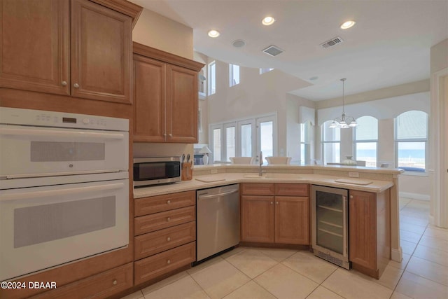 kitchen with wine cooler, a chandelier, a healthy amount of sunlight, and stainless steel appliances