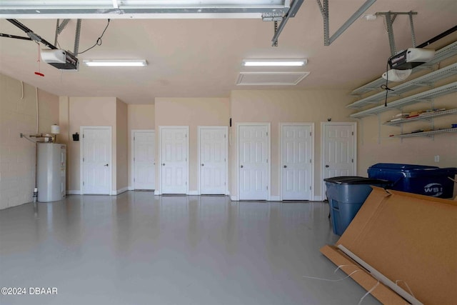 garage with a garage door opener and electric water heater