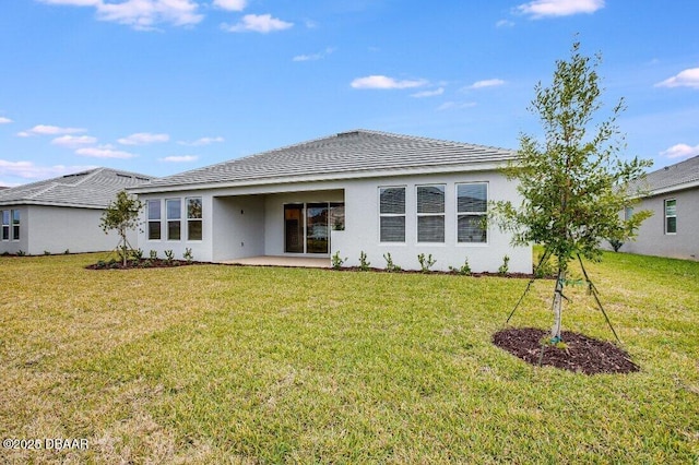 rear view of property with a yard and a patio area