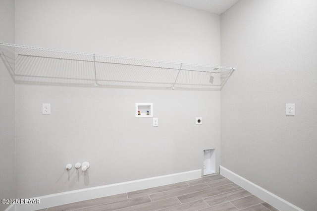 clothes washing area with hookup for a washing machine, gas dryer hookup, hardwood / wood-style flooring, and hookup for an electric dryer