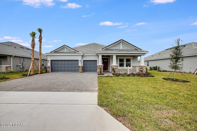 view of front of home featuring a porch, a garage, and a front lawn