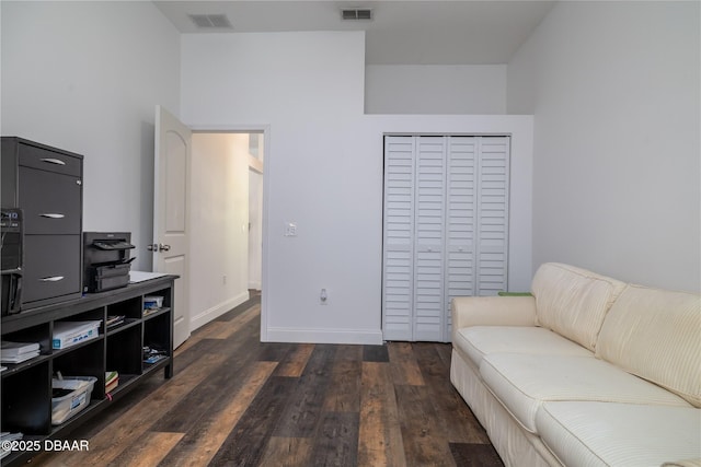 sitting room featuring a high ceiling, baseboards, visible vents, and wood finished floors