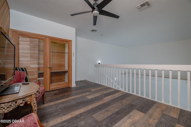 interior space featuring an upstairs landing, ceiling fan, visible vents, and wood finished floors