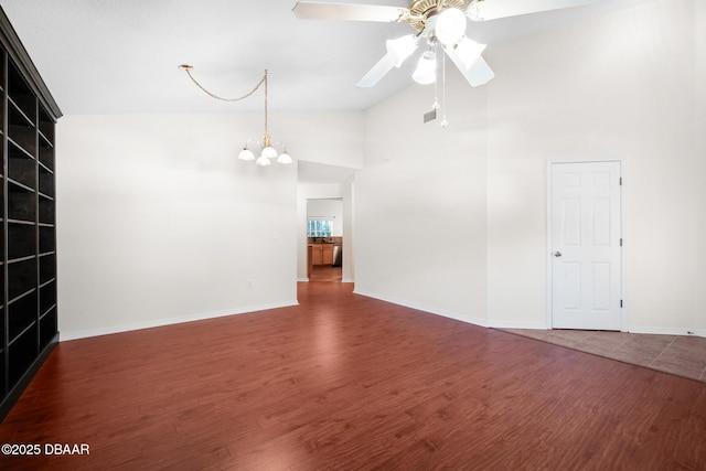 unfurnished room with ceiling fan with notable chandelier, wood finished floors, and baseboards