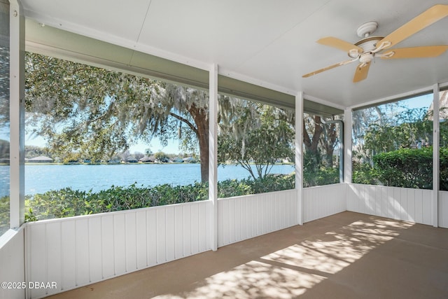 unfurnished sunroom featuring a water view and ceiling fan