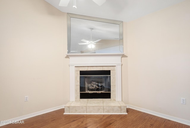 room details featuring ceiling fan, a fireplace, baseboards, and wood finished floors