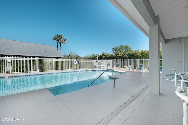 community pool with a patio and fence