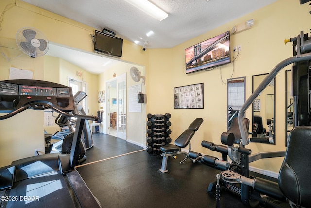 exercise room featuring baseboards and a textured ceiling