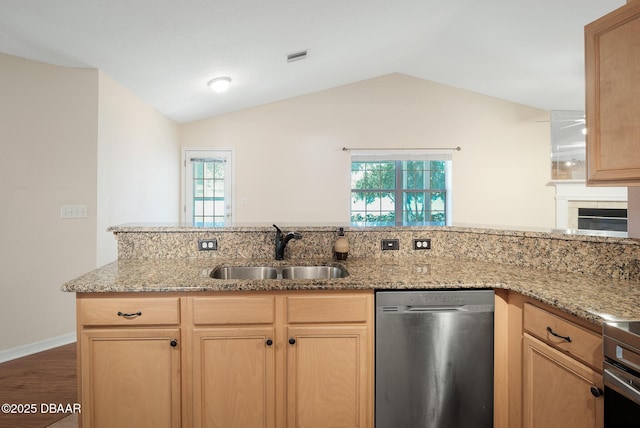 kitchen featuring light stone counters, vaulted ceiling, a sink, and stainless steel dishwasher