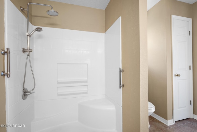 full bathroom featuring tile patterned floors, baseboards, toilet, and walk in shower