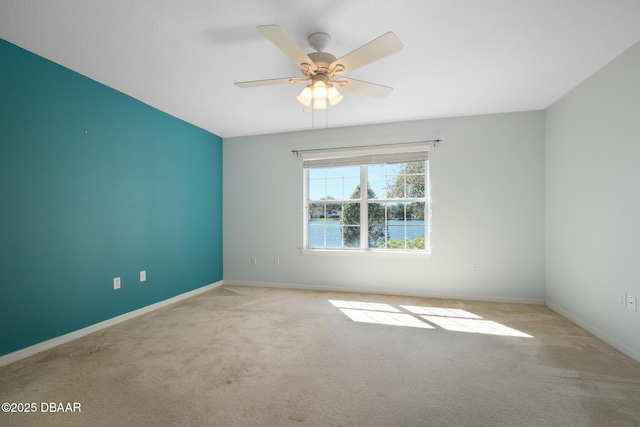 spare room featuring ceiling fan, baseboards, and carpet flooring