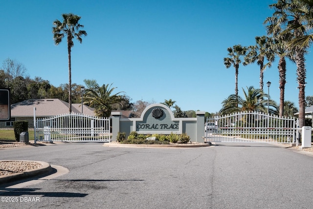 view of road with a gate, a gated entry, and curbs